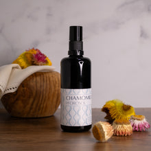 Chamomile Hydrosol on a wooden platform with dried strawflowers around it