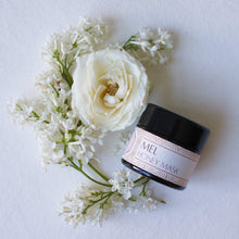 Mel Honey Mask on a white background with a white rose and lilacs