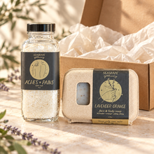 Seagrape bath soak and Lavender Orange soap styled in a gift box with tissue; styling props not included.