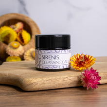 Jar of Sirenis Cleansing Balm with dried flowers on a wooden surface