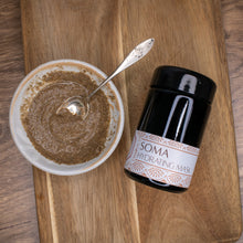 Jar of dry face mask next to a small bowl of prepared face mask on a wooden background