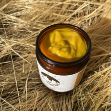 Jar of yellow cream on a bed of dry grass