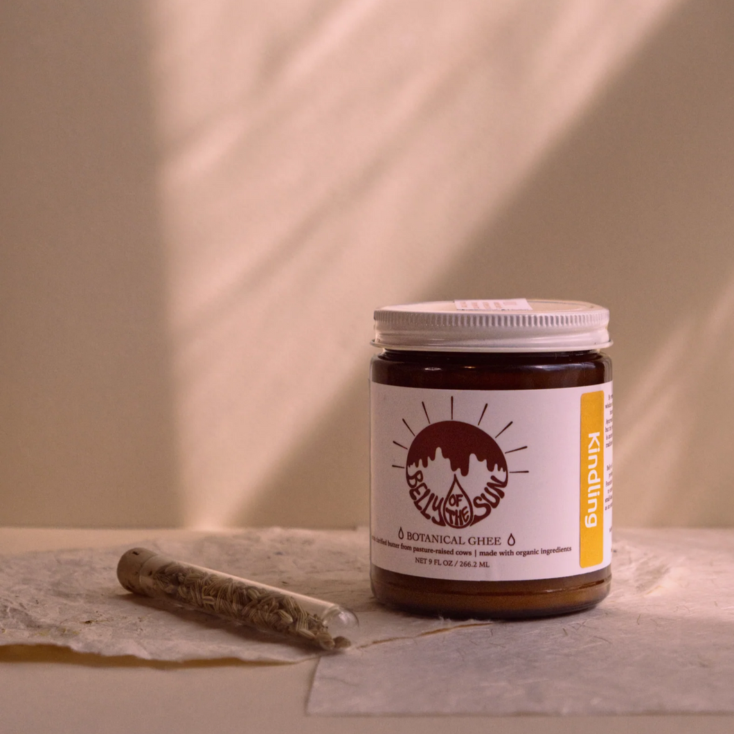 Jar of botanical ghee with a label on a neutral background
