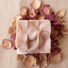 three bars of pink soap on rose petals