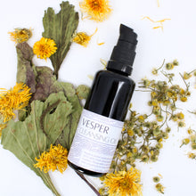 Flatlay photo of a bottle of Vesper Cleansing Oil on a white background with calendula, chamomile, and plantain 